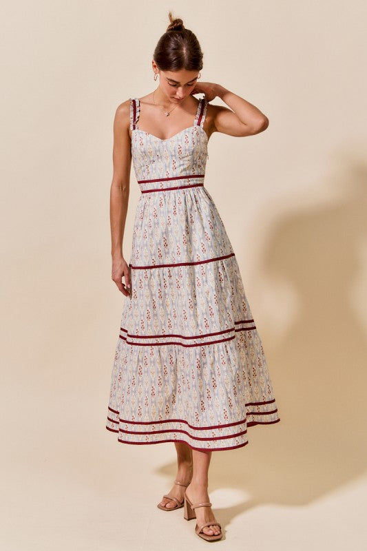 Woman wearing a floral dress with red accents against a beige background