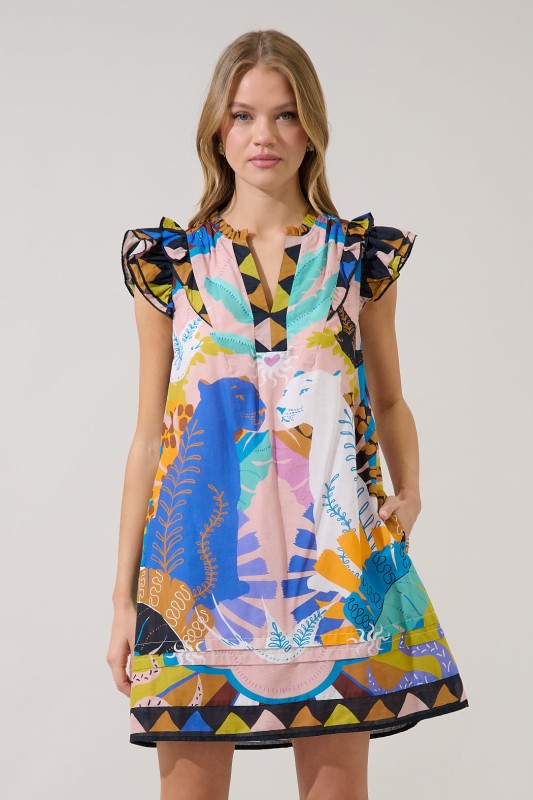 Woman wearing a colorful patterned dress outside with plants 