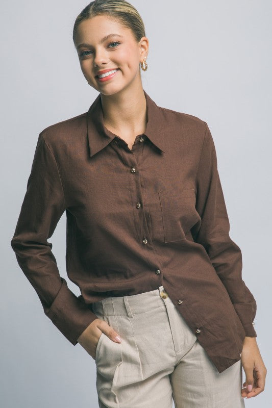 Woman wearing a brown button-up shirt against a plain background