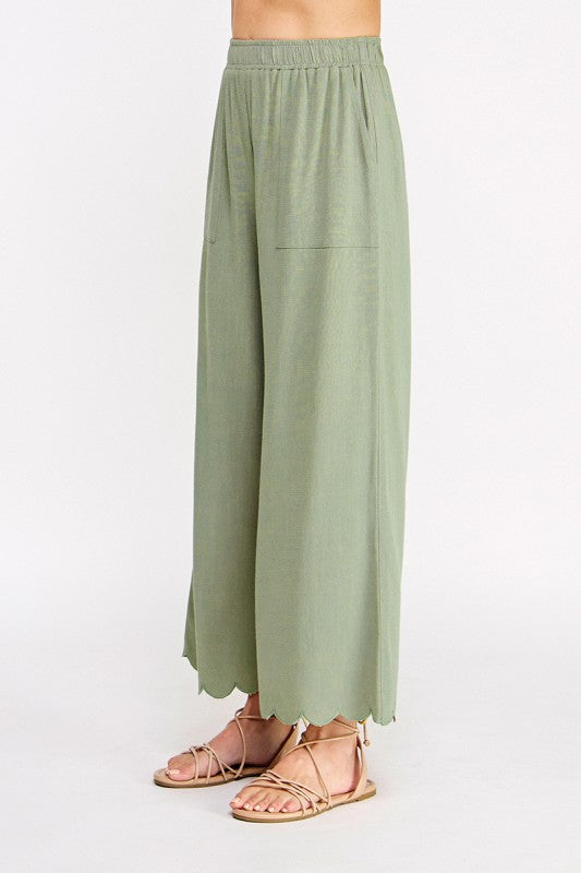 Green wide-leg pants worn by a person on a white background