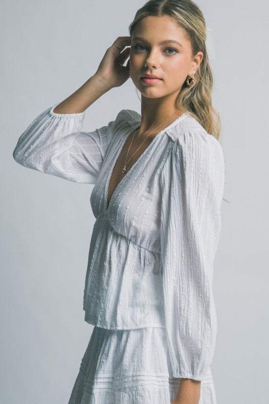 Woman wearing a light blue dress with a plain background