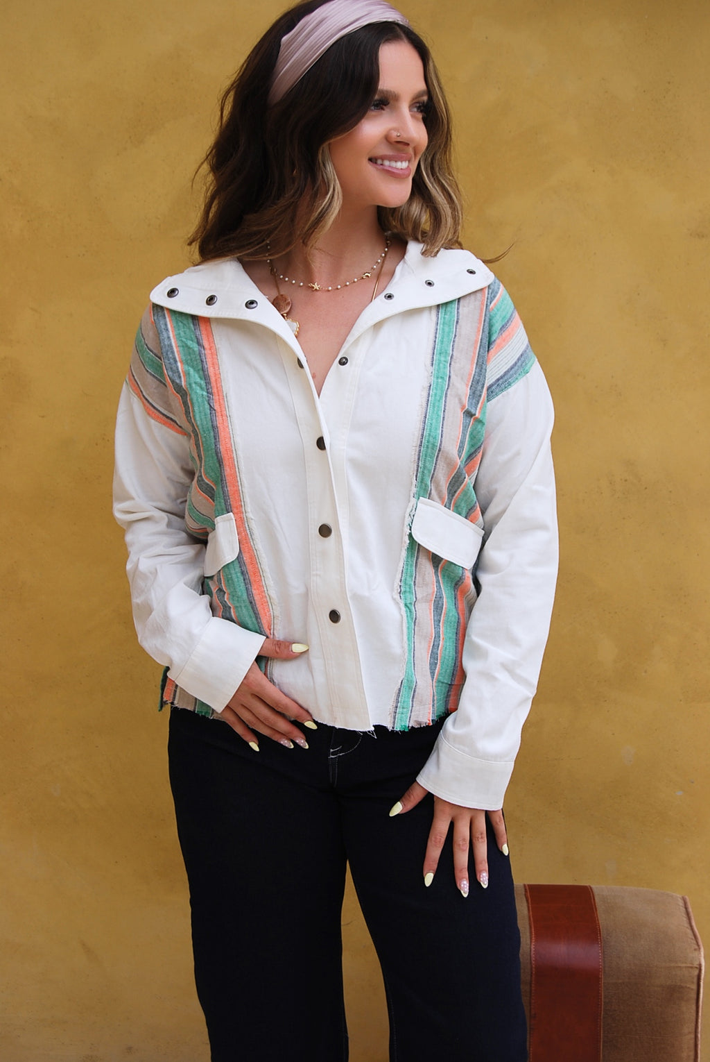 White jacket with colorful striped pattern over a yellow background