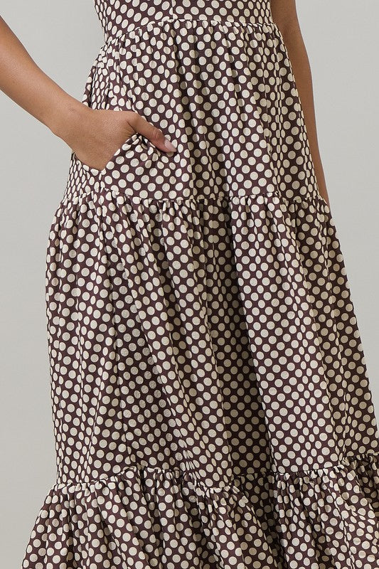 Woman wearing a polka dot dress with a plain background