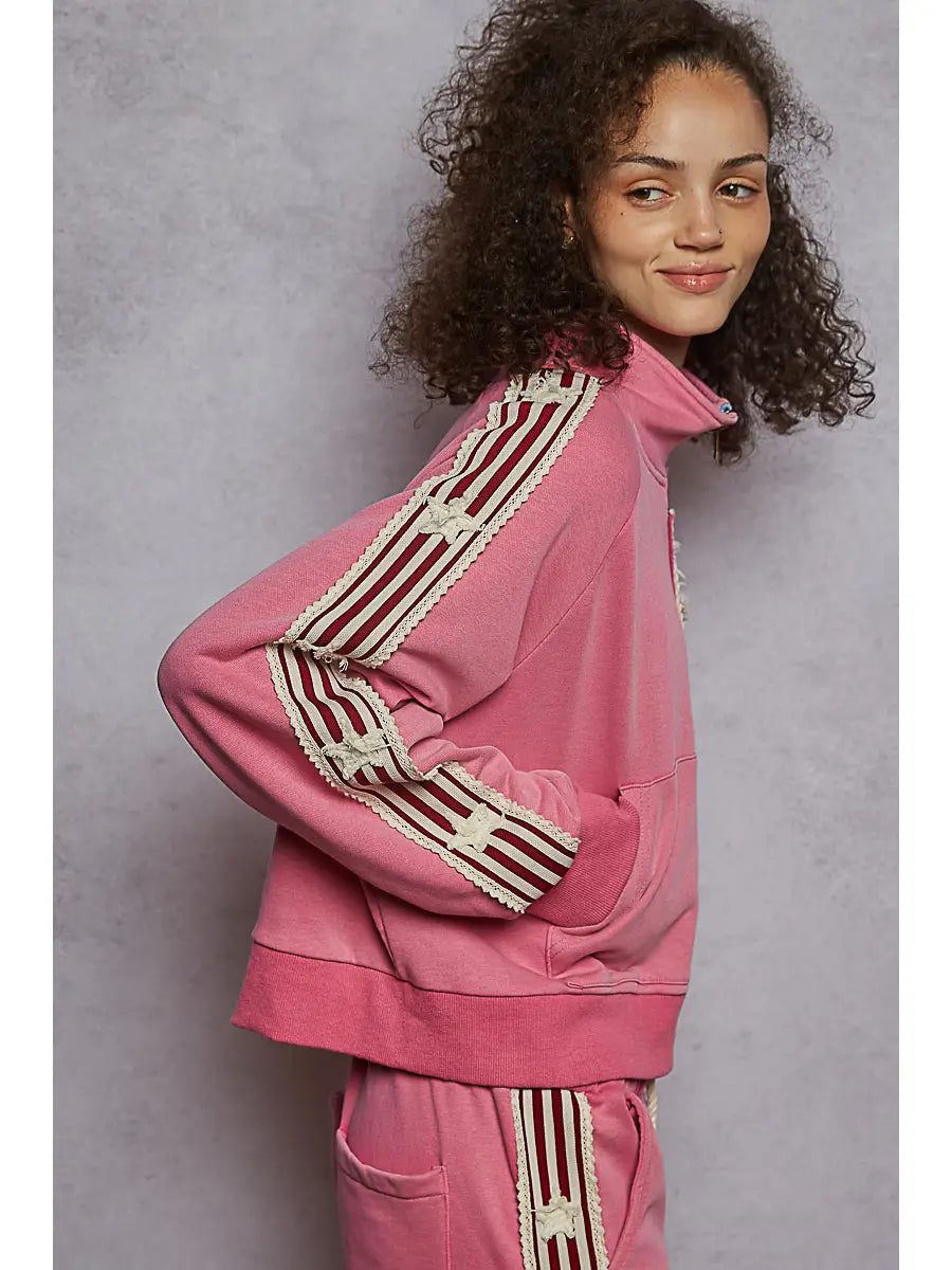 Person wearing a pink tracksuit with a star design on a gray background