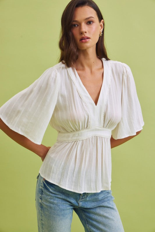 Woman sitting on a chair with an acoustic guitar indoors