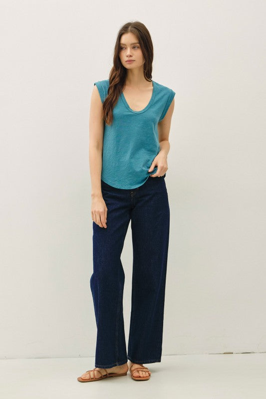 Woman wearing a teal sleeveless top against a plain background