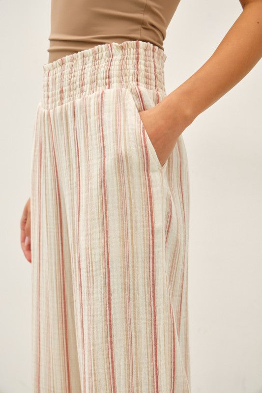 Person wearing light striped pants on a white background