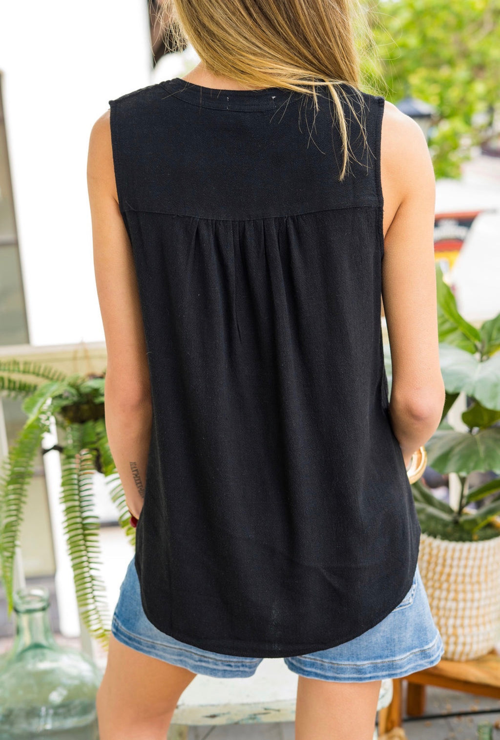 Women wearing a black shirt with blue shorts with a blur background 