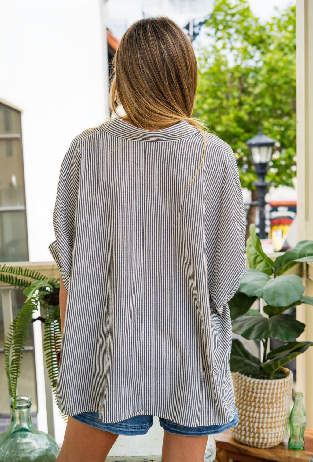 women wearing a stripe shirt with blue shorts outside 