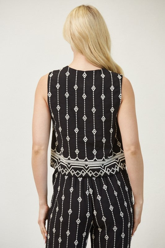 Woman wearing a black and white patterned jumpsuit on a plain background