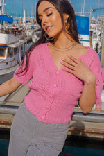 girl standing on wharf in Monterey California wearing a bubblegum pink cropped cardigan