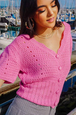 girl standing on wharf in Monterey California wearing a bubblegum pink cropped cardigan