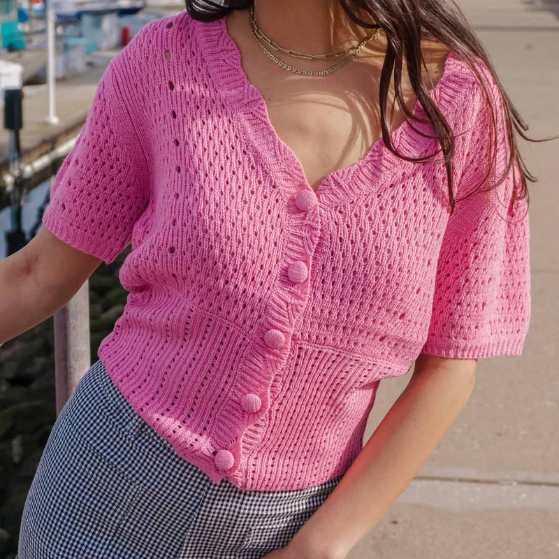 girl standing on wharf in Monterey California wearing a bubblegum pink cropped cardigan